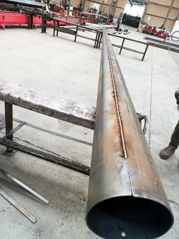 Longitudinal weld seam running the length of a tapered steel lighting pole shaft before galvanizing