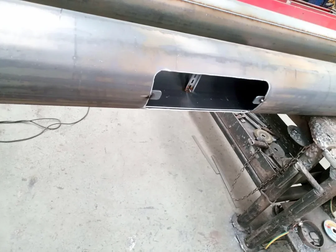 Access door aperture and internal mounting rail on a steel lighting pole shaft, before coating
